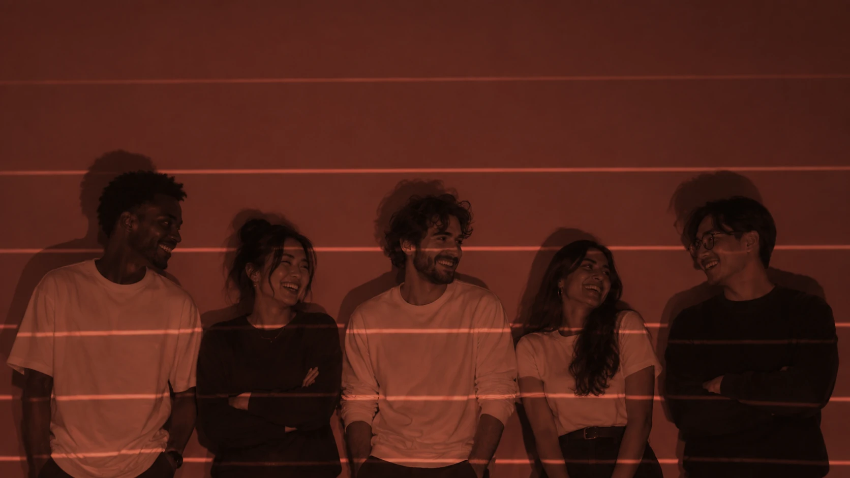 Five members of the Afterform team laughing together in a red-lit studio