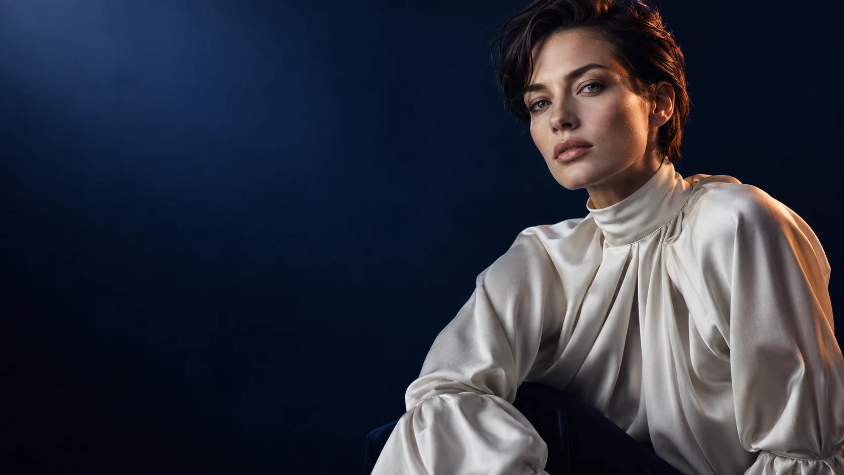Fashionportret met een lichte blouse, blauw studiolicht en ruimte voor de kop